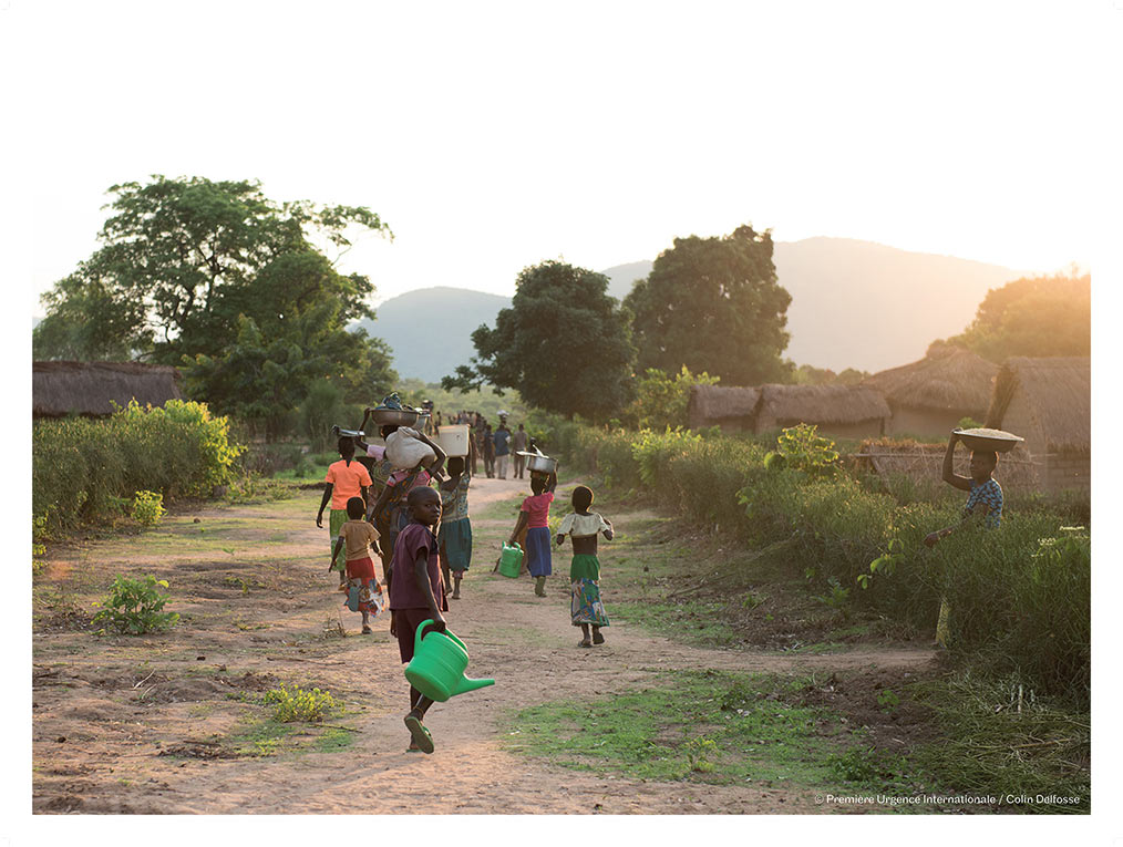 Les habitants de Kaluala retournent dans leur village après avoir reçu du matériel agricole et des semences. 